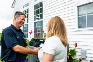 Trane Comfort Specialist Shaking Hands With Woman Outside Of Her Home