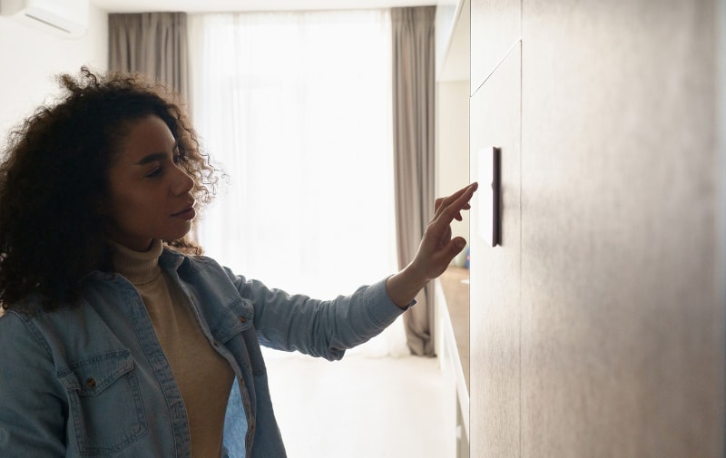 Woman Using Smart Thermostat
